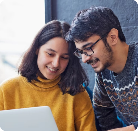 Young couple smiling at laptop